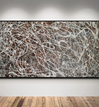 Number 15 – Jackson Pollock Style Brown Abstract Canvas displayed under spotlights, highlighting its elegant white, sand, and black splashes over a brown background