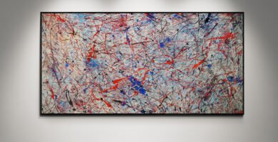 Number 20, Jackson Pollock Inspired Red and Blue Abstract Canvas displayed in a modern gallery with spotlights