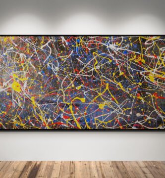 Number 45 – Abstract painting with intense splashes of red, yellow, blue, and white in a Jackson Pollock style, displayed in a gallery setting with a wooden floor