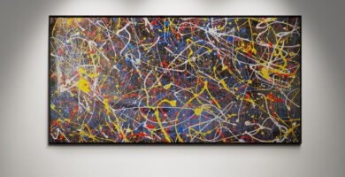 Number 45 – Abstract painting with intense splashes of red, yellow, blue, and white in a Jackson Pollock style, displayed in a gallery setting with a wooden floor