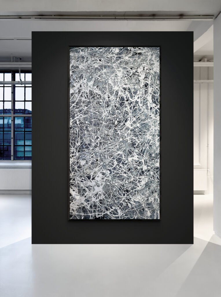 Number 30 - Jackson Pollock Style Monochrome Abstract Canvas displayed in a modern art gallery with a black accent wall, illuminated by soft overhead lighting, emphasizing its intricate white and gray patterns