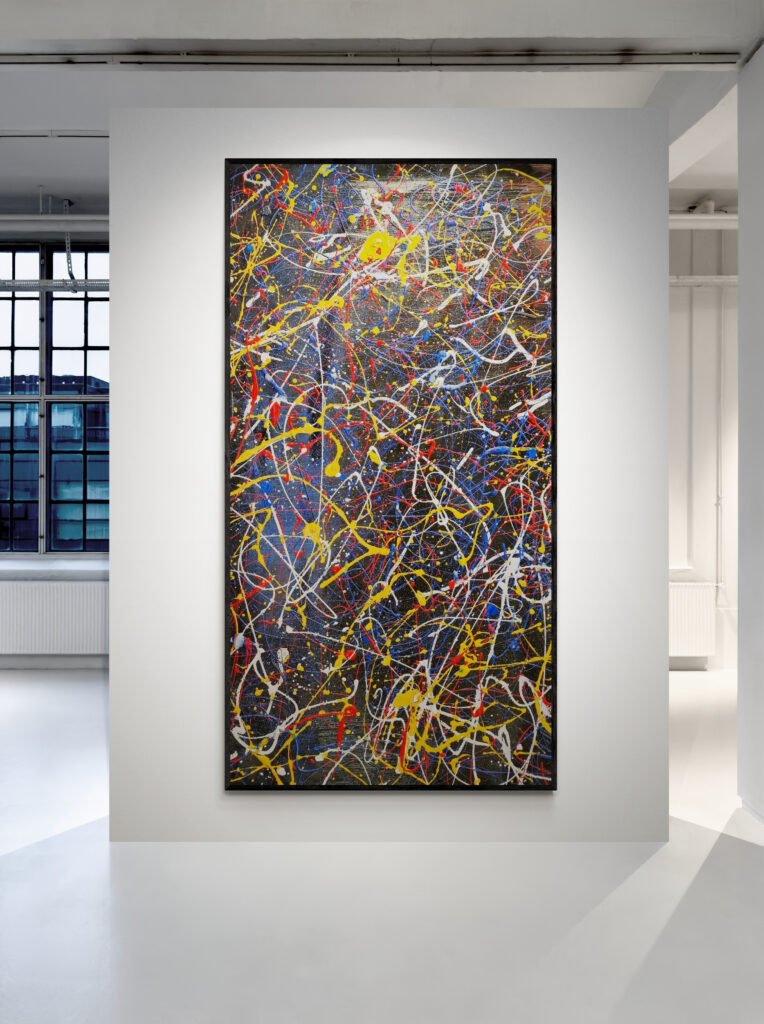 Vertical display of Number 45 – Abstract painting in vibrant colors, mounted on a white gallery wall with modern architecture in the background