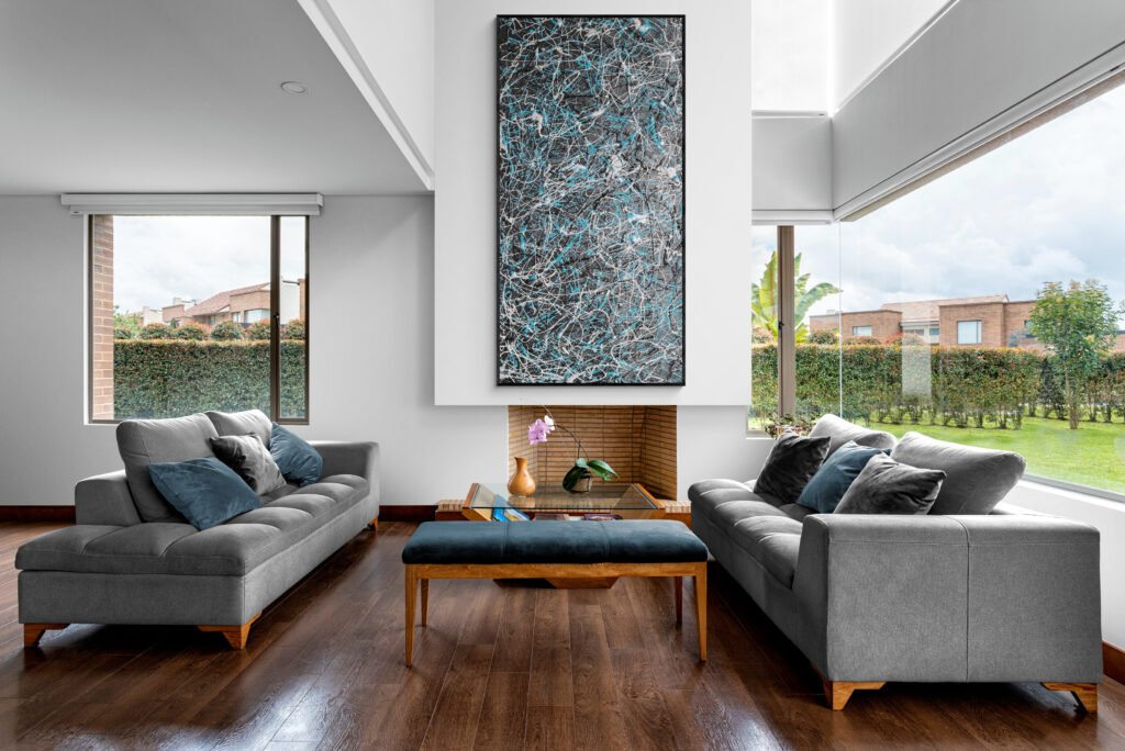 Number 27 hung in a cozy living room with garden views, showcasing its vibrant black and turquoise splashes