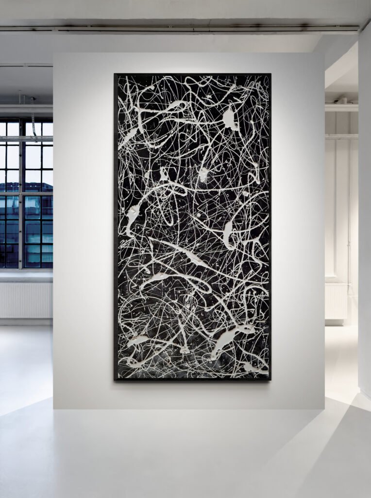 Vertical view of "Number 77" abstract monochrome canvas displayed in modern gallery with industrial window background