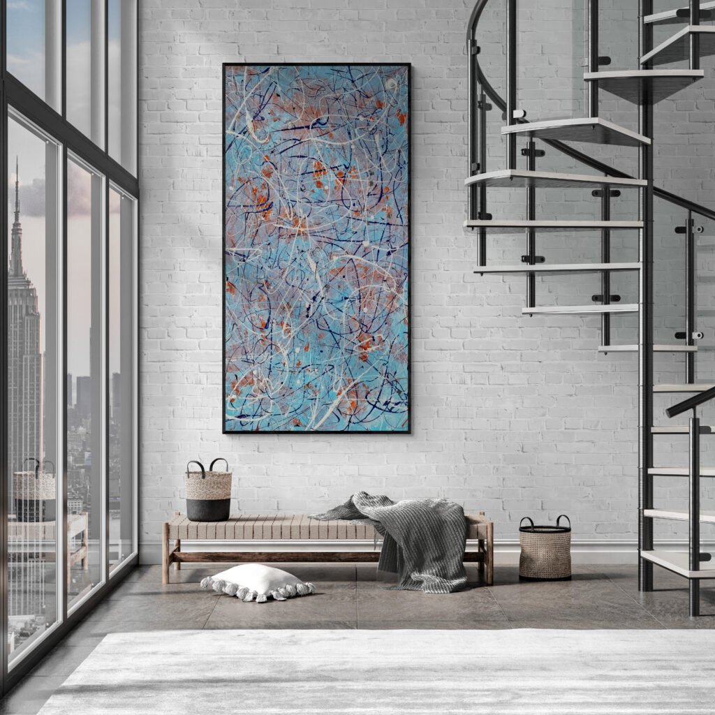 Large vertical drip-style canvas in blue and orange hues, mounted on a white brick wall beside a modern spiral staircase with city view.